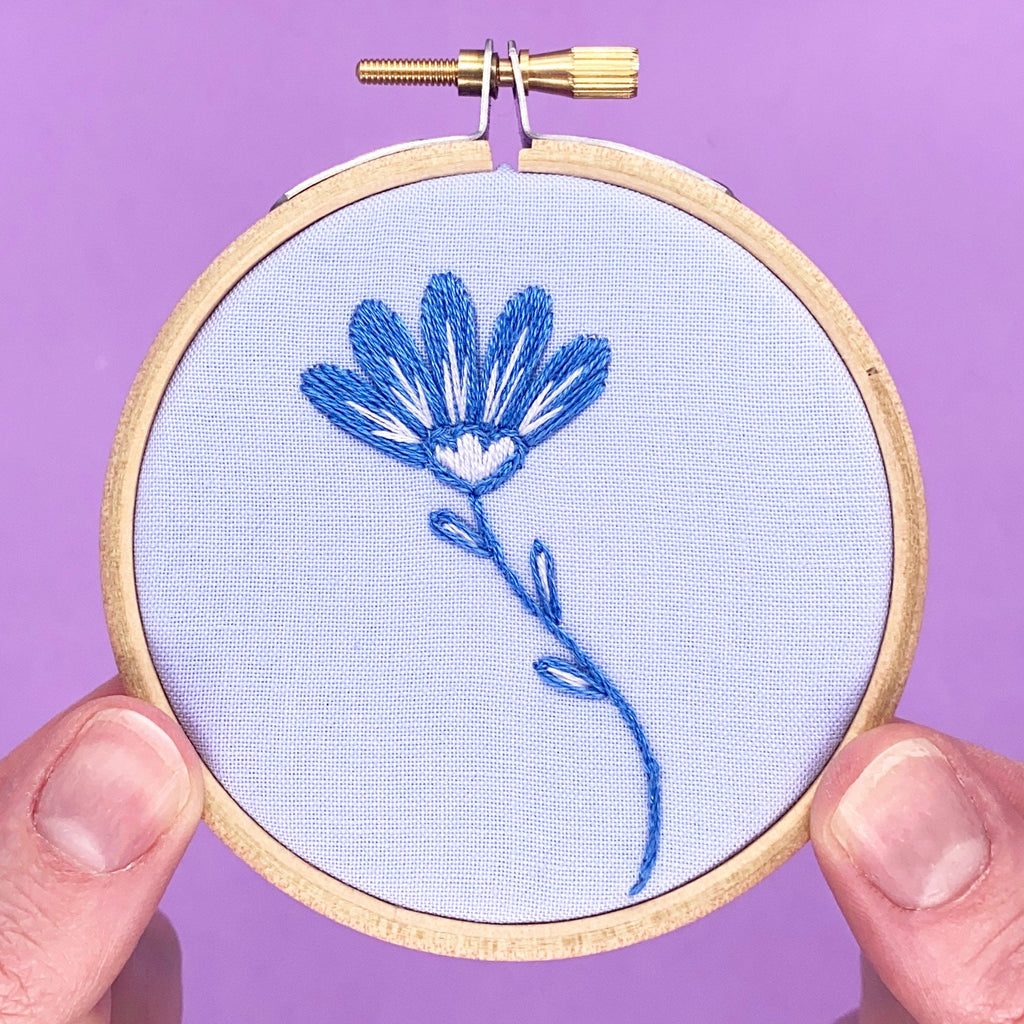 Purple flower in embroidery in a hoop