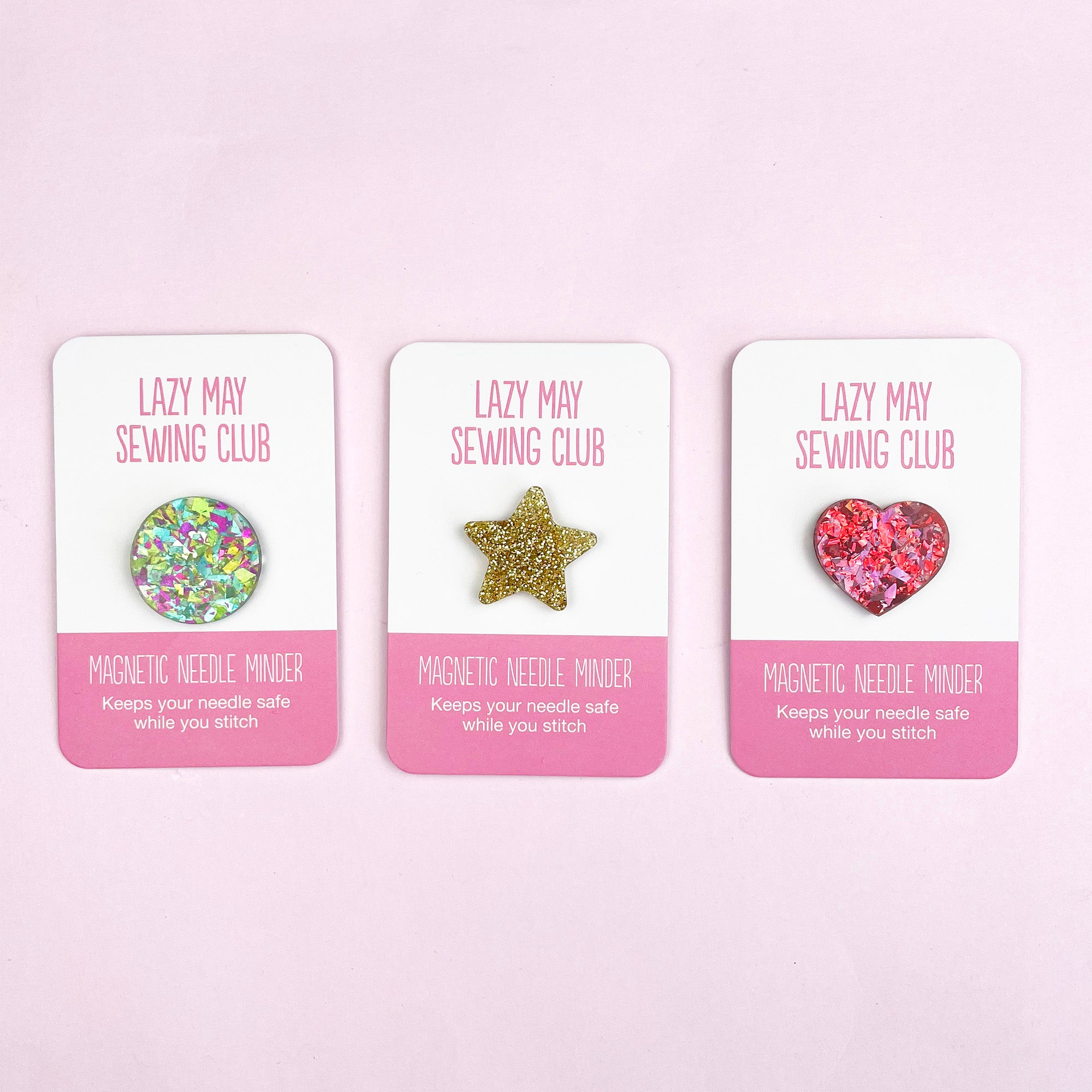 Set of colorful magnetic needle minders in round, star, and heart shapes for easy embroidery needle storage.