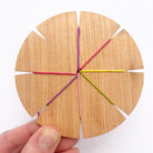 wooden loom using for weaving friendship bracelets show with threads positioned in the slots
