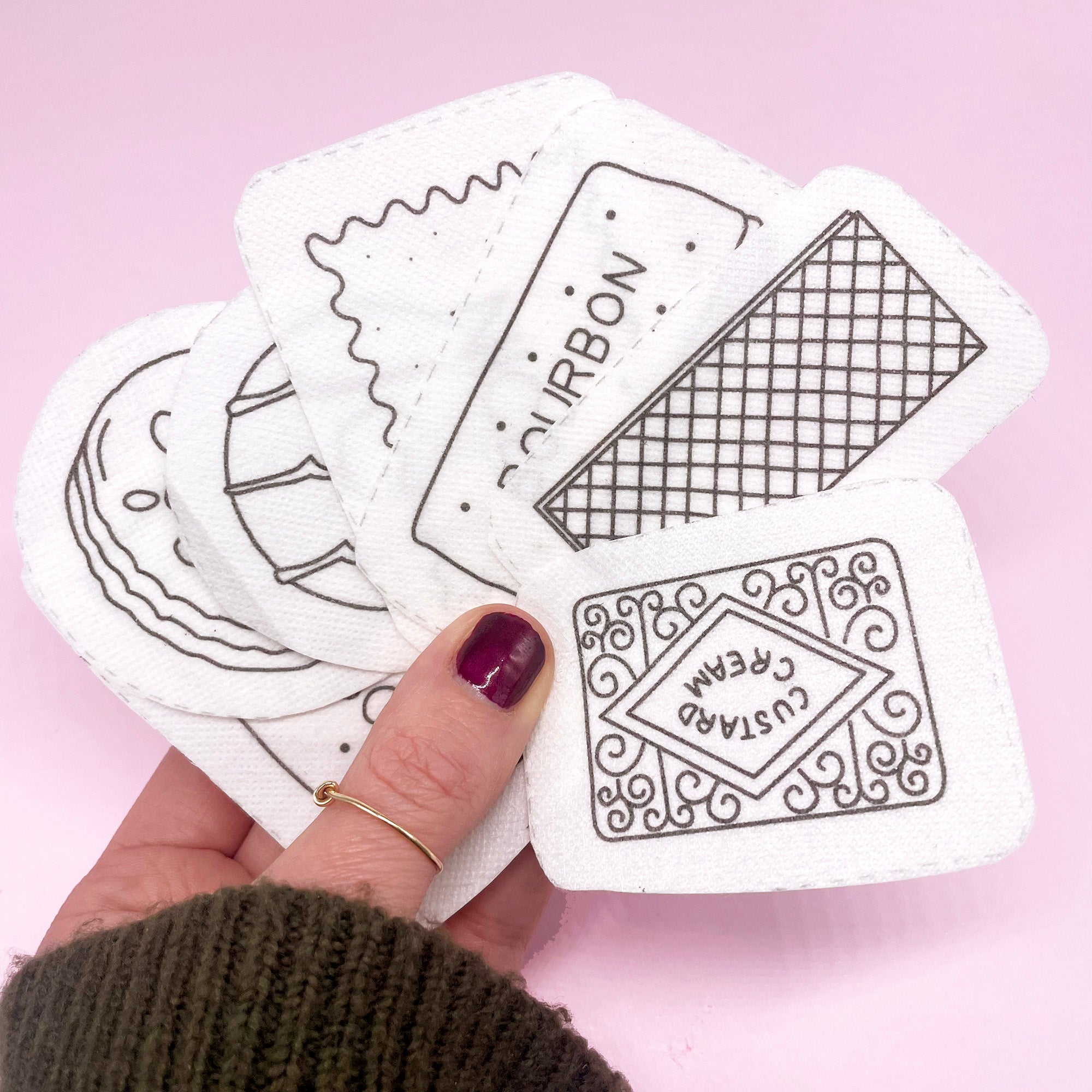 A fan of British biscuit embroidery patterns printed on dissolving fabric, ready for stitching. These modern embroidery designs make personalising fabric projects simple and fun.