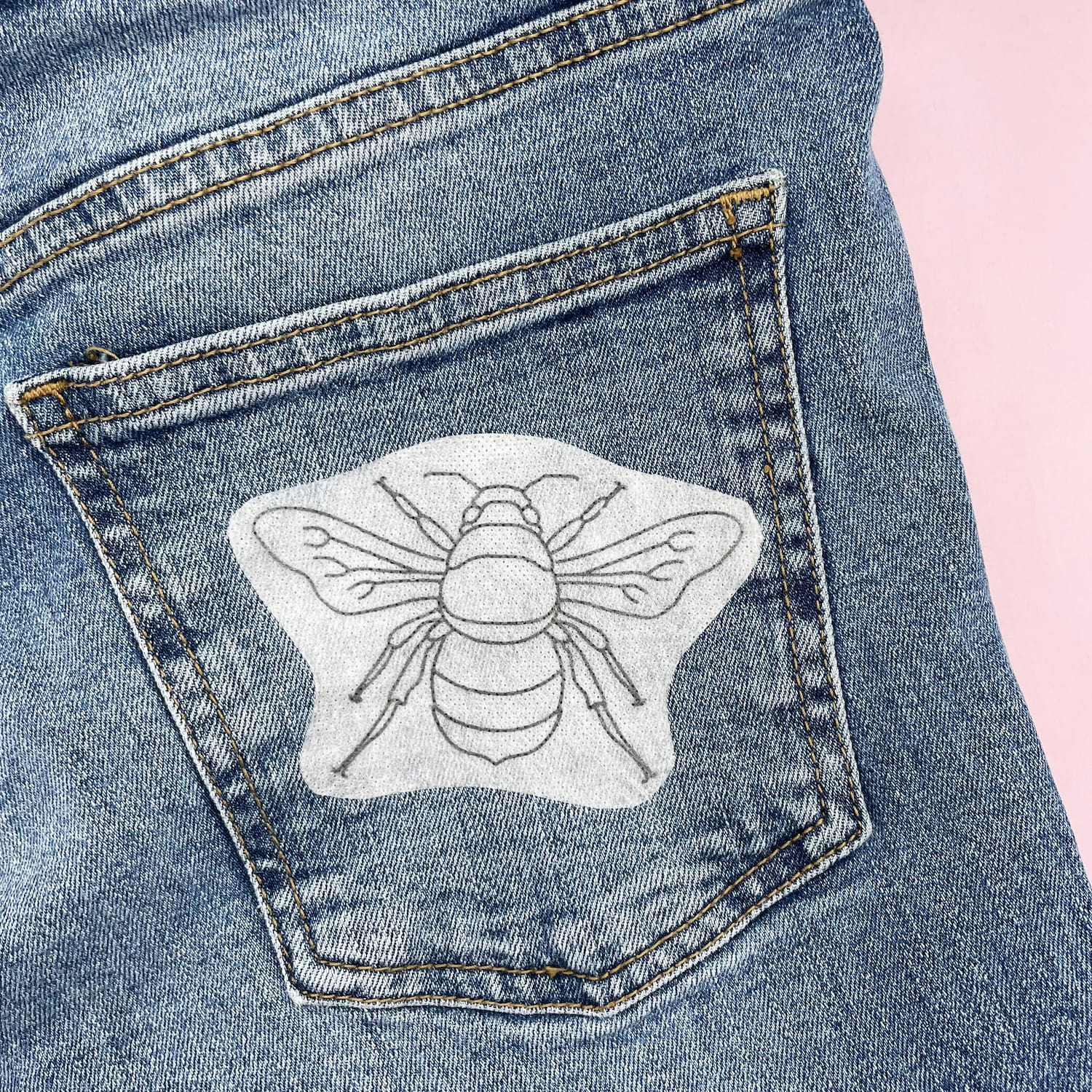 Bee embroidery design outlined on denim back pocket using Beautiful Bugs Stick and Stitch Embroidery Patterns