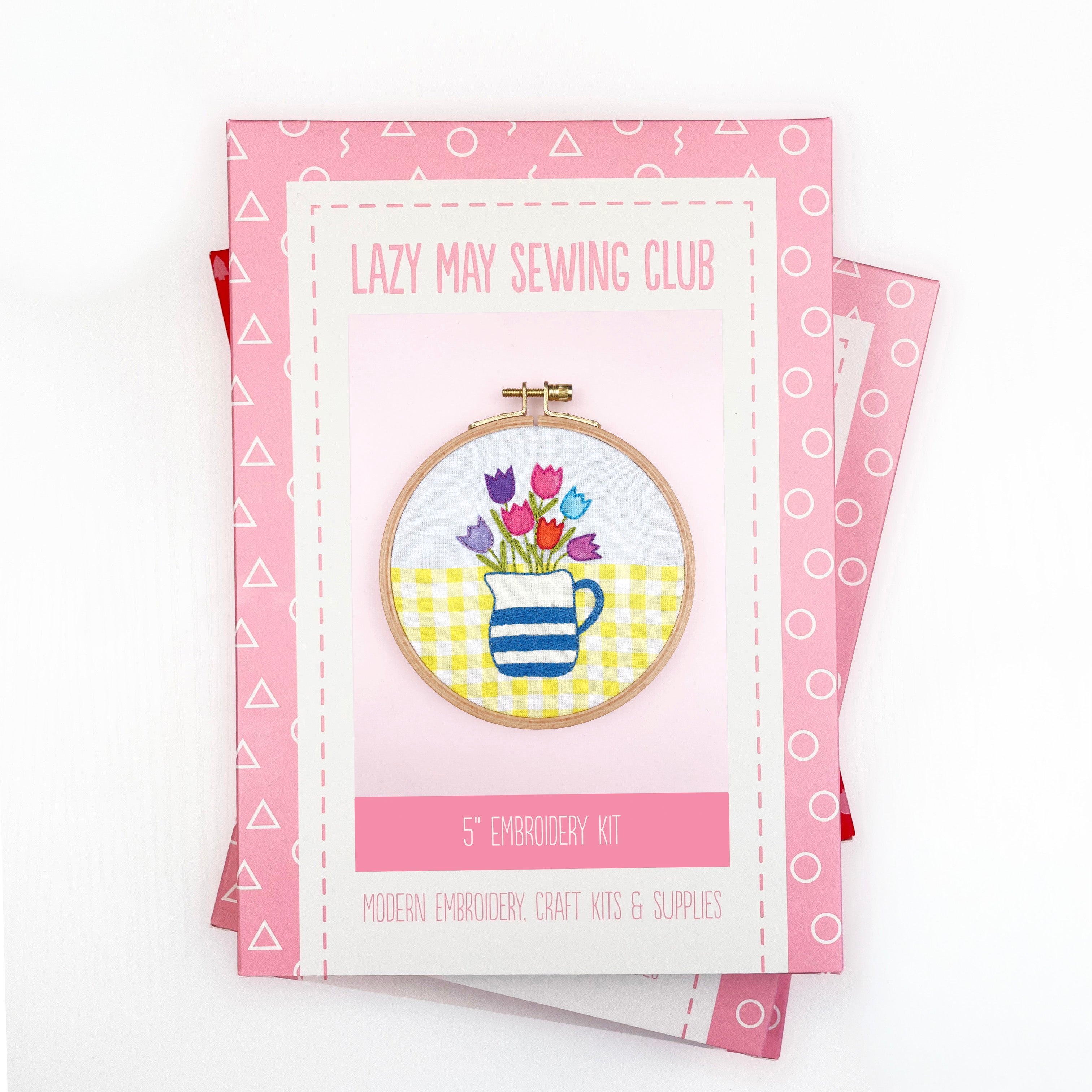 Embroidery kit packaging with a design of tulips and a cup on a white background