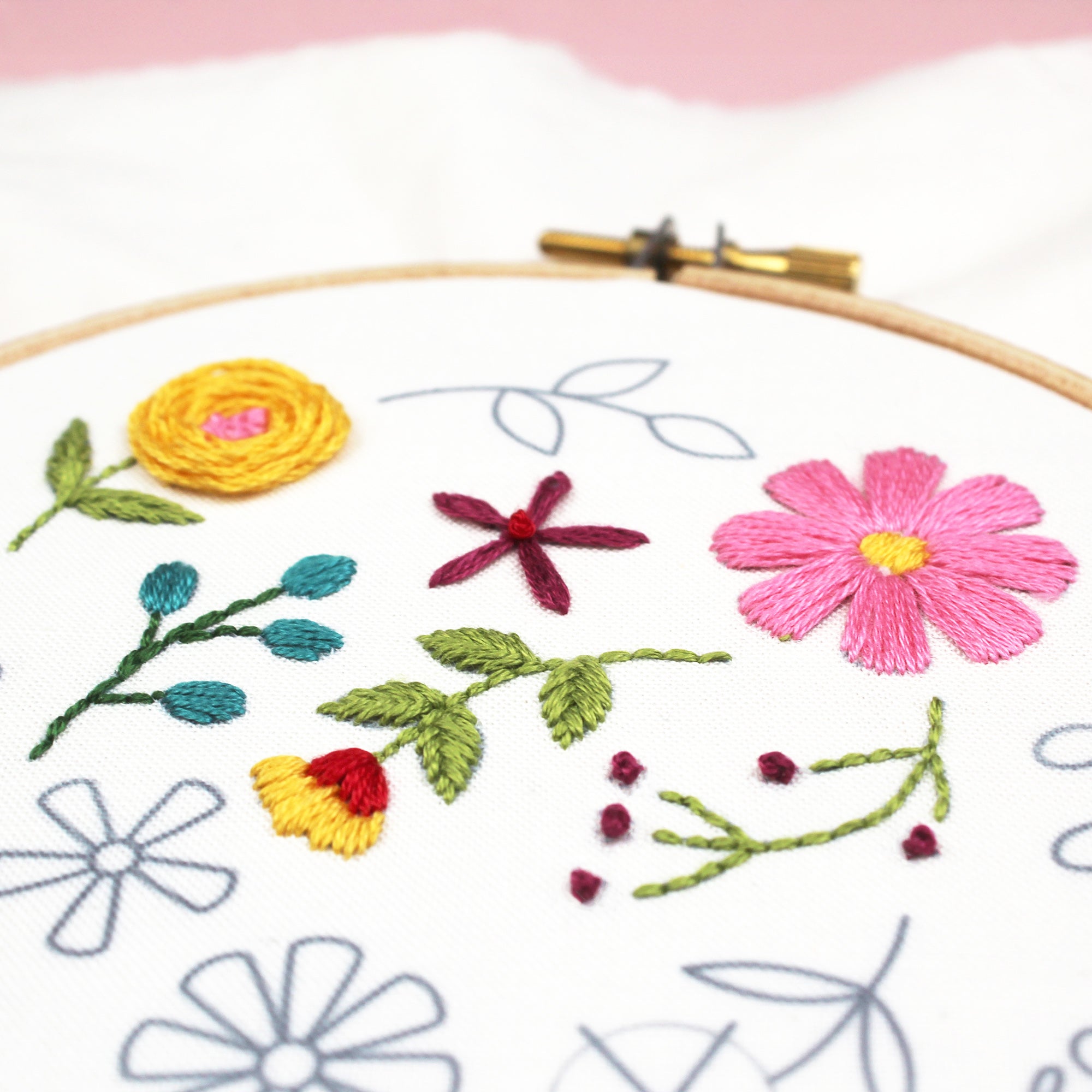 In-progress embroidery on pre-printed fabric showing floral design being stitched – beginner-friendly needlework kit.
