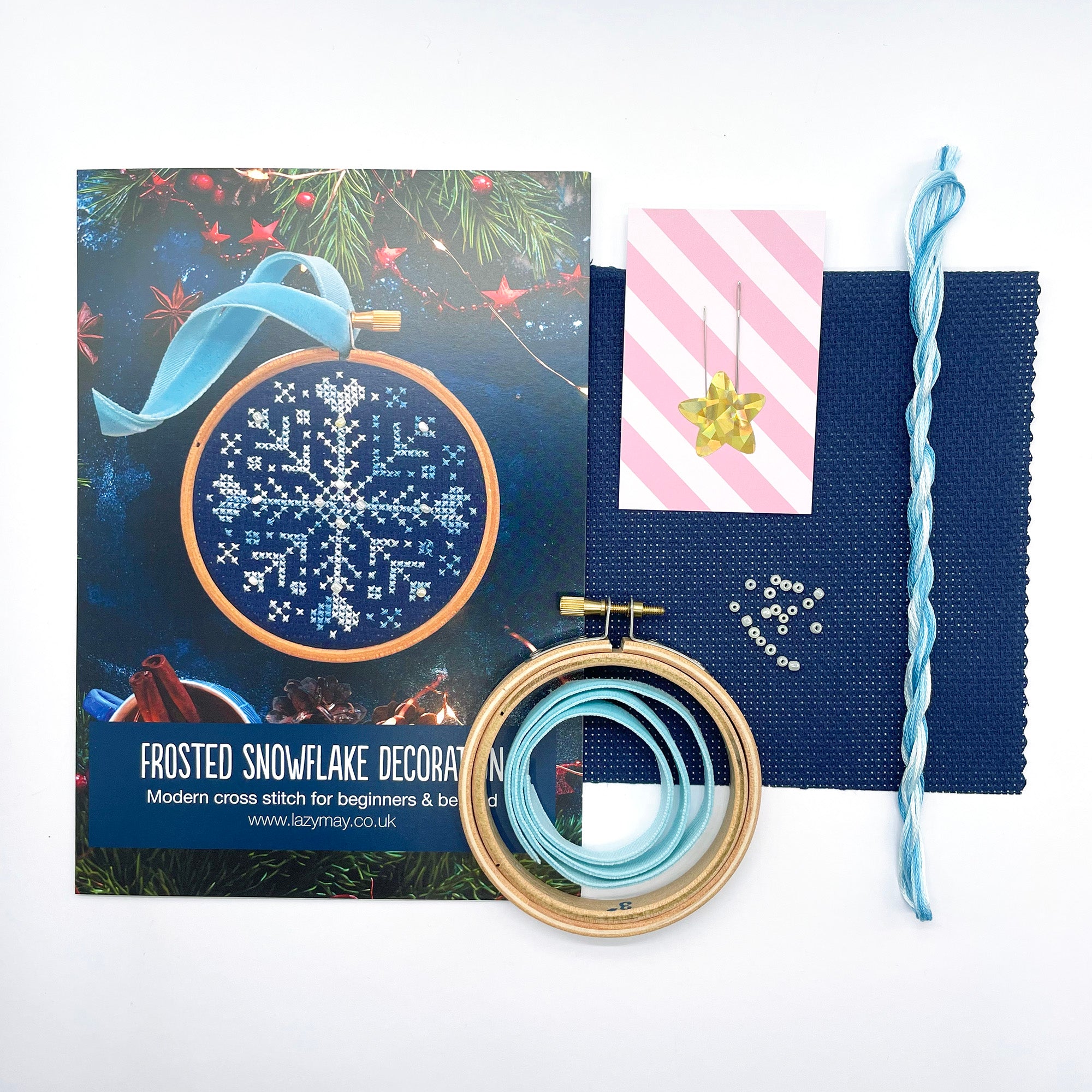 Beaded Snowflake Christmas Cross Stitch Kit with blue fabric, thread, wooden hoops, needles, and beads for embroidery projects.