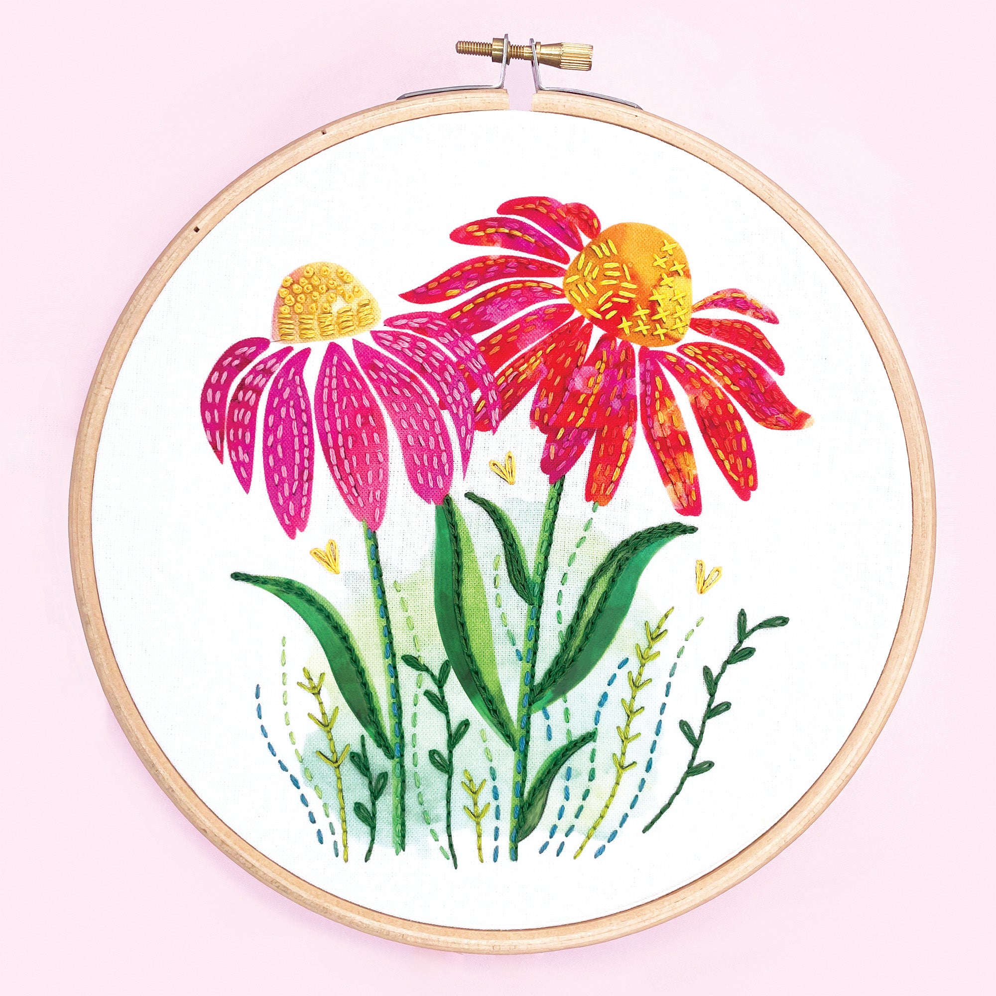 A floral embroidery kit depicting vibrant Echinacea flowers on a 7" wooden embroidery hoop, with a pink background.