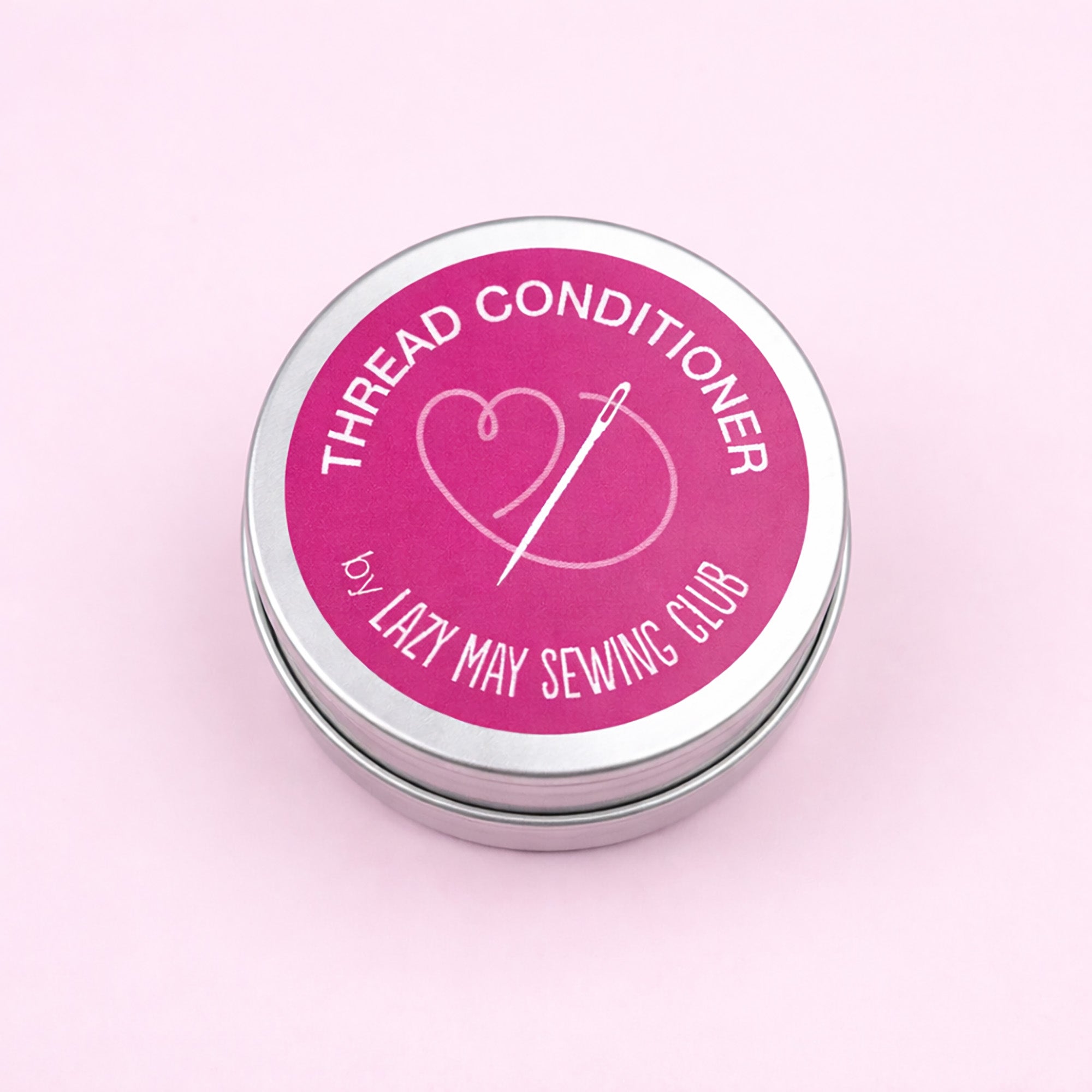 Thread festive conditioner container with pink label on a light pink background