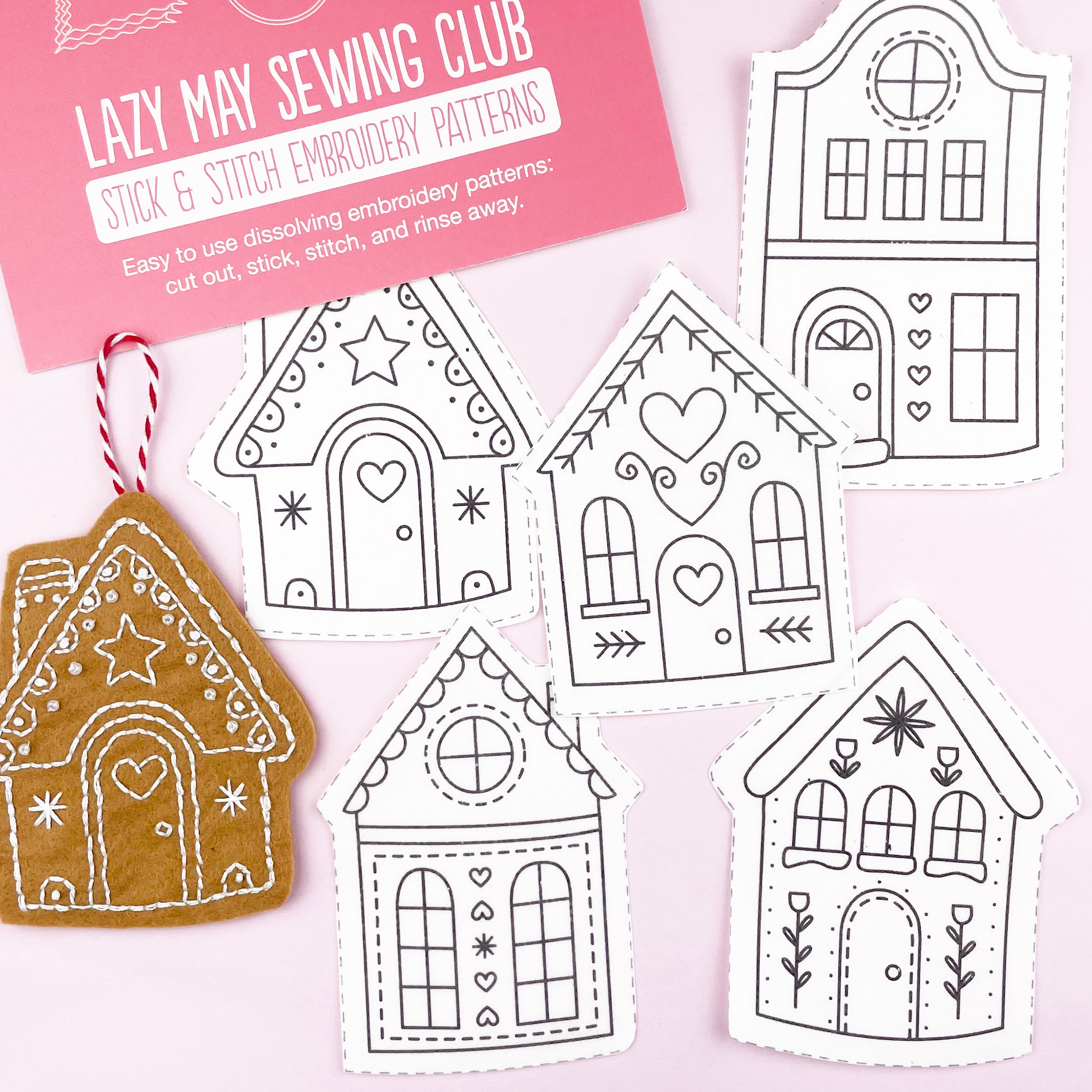 Embroidery patterns of christmas gingerbread houses with a pink card labeled 'Lazy May Sewing Club' on a light pink background.