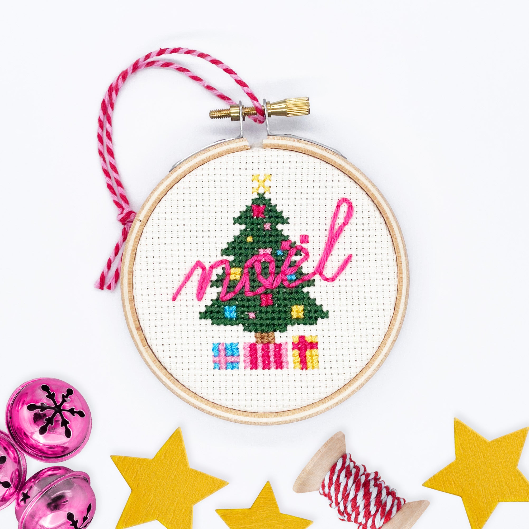Christmas Tree: Cross Stitch Kit with decorated tree, colorful gifts, and pink noel text in wooden embroidery hoop.