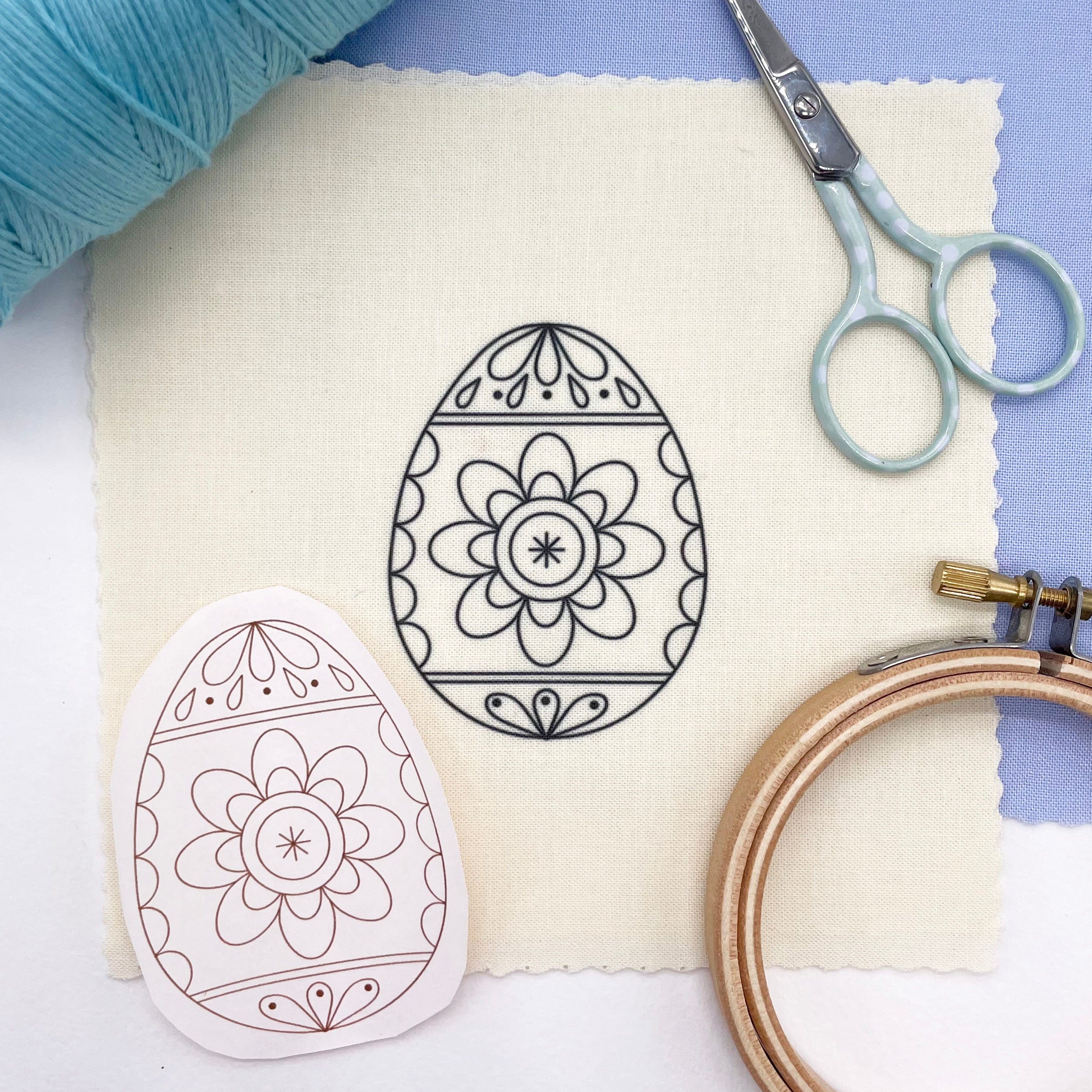 Easter embroidery design of a floral Easter egg transferred onto fabric, shown alongside the original iron-on pattern. Perfect for Easter crafts and DIY stitching projects.