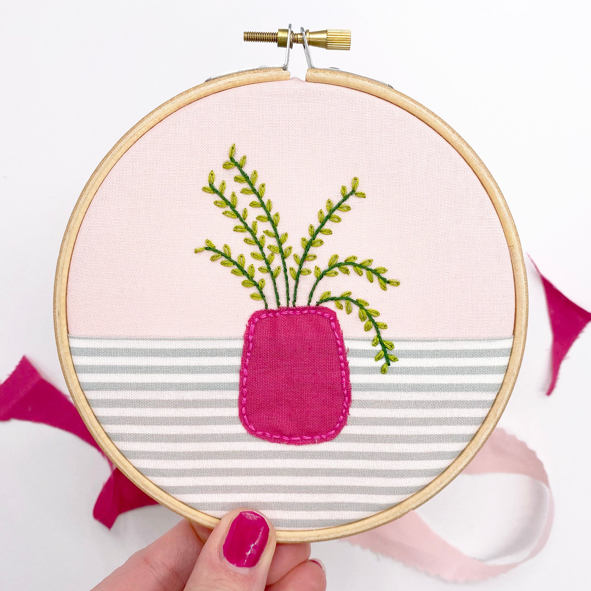 A finished embroidery hoop featuring a house plant stitched from the dissolving pattern set, with an appliqué vase for added texture.