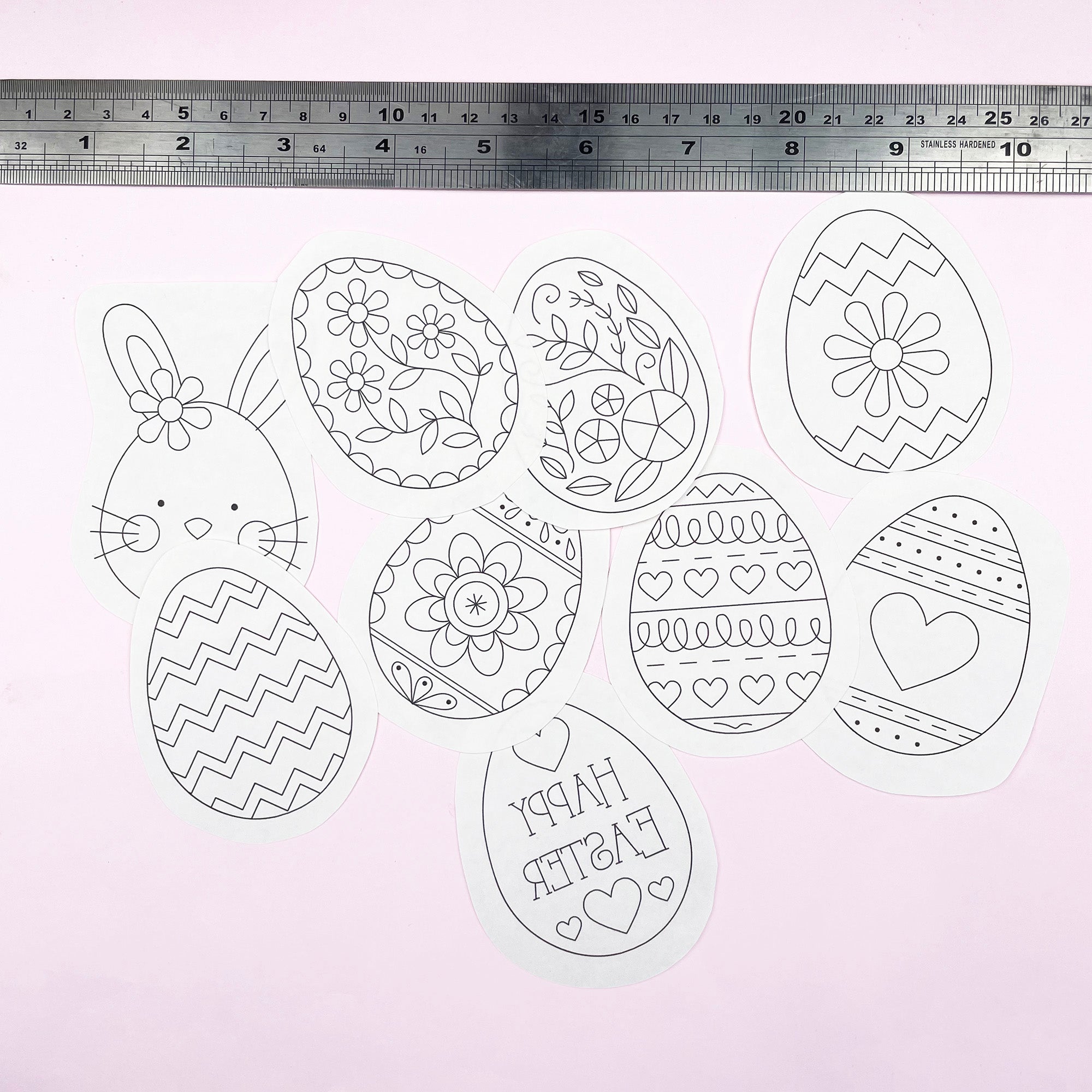 Decorative Easter egg and bunny templates with a ruler for scale on a light pink background.