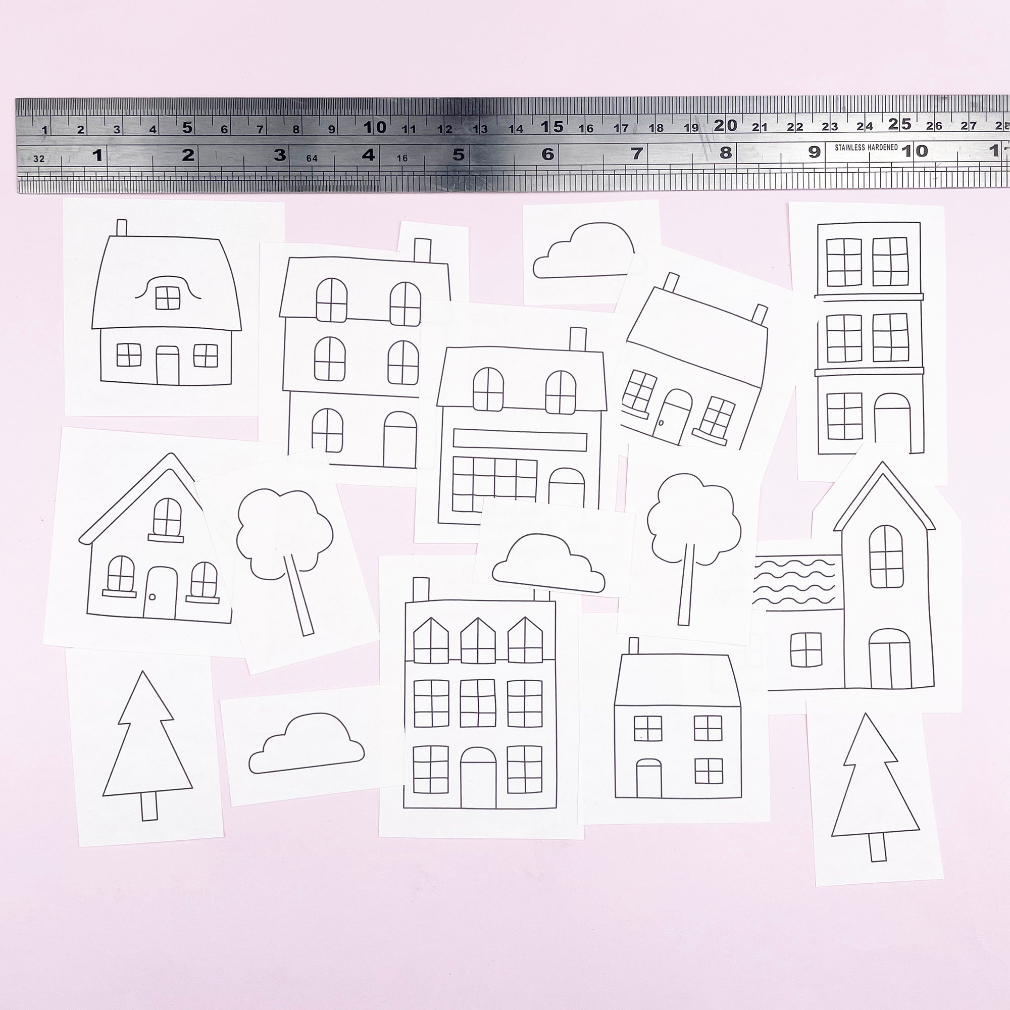 Set of black and white embroidery transfers with house and tree outlines with a ruler on a light pink background