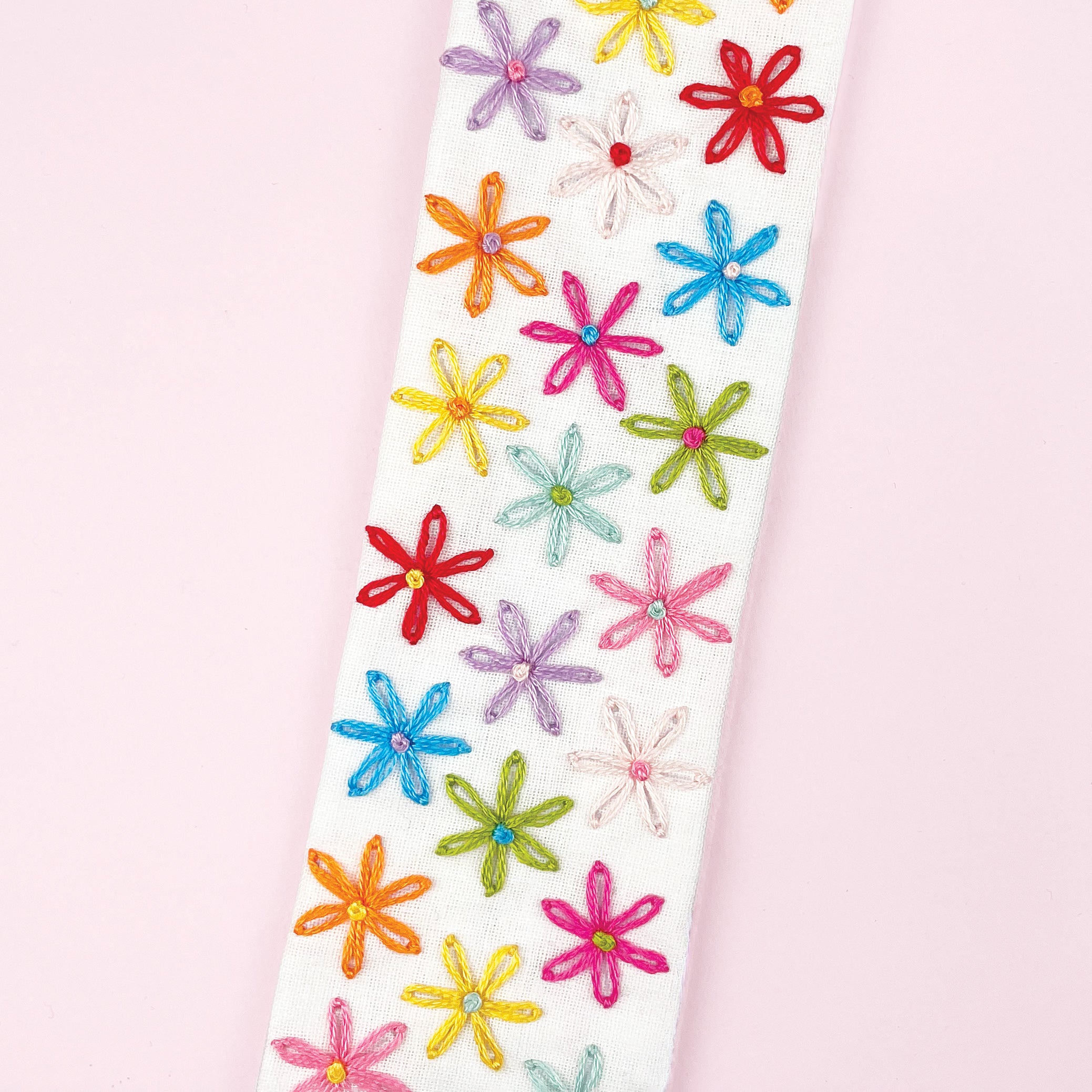 Colorful flower-shaped stickers on a white background, close up of floral bookmark made from Hand embroidered bookmark making kit