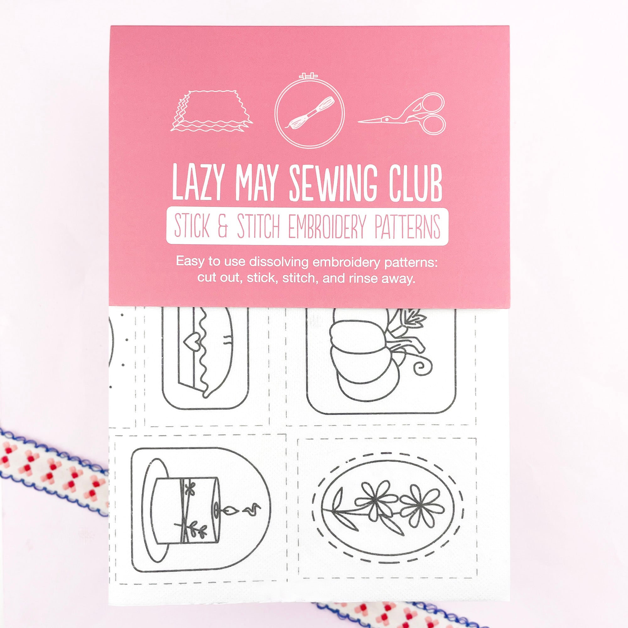Packaging of Lazy May Sewing Club stick and stitch embroidery patterns on a pink background.