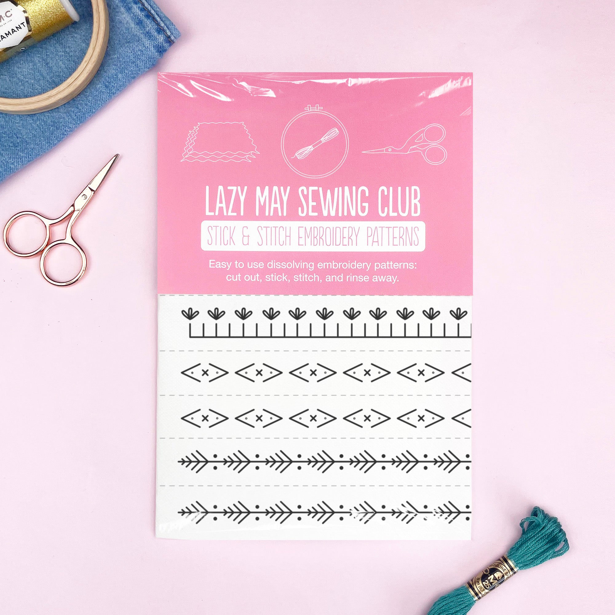 Decorative Borders: Stick and Stitch Embroidery Patterns with black line designs, scissors, thread, and fabric on pink background