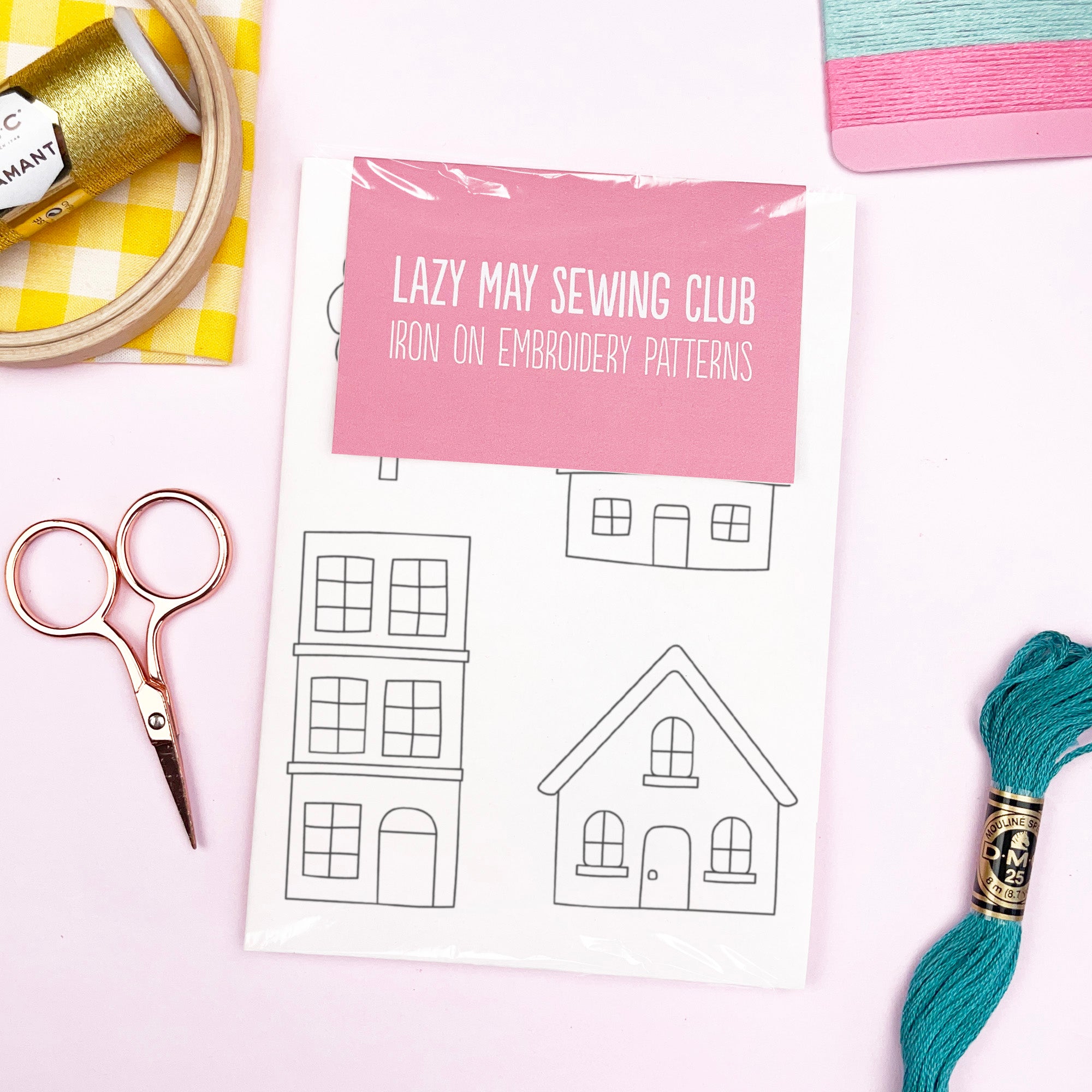 Iron on embroidery patterns with cottage designs and sewing tools on a white background