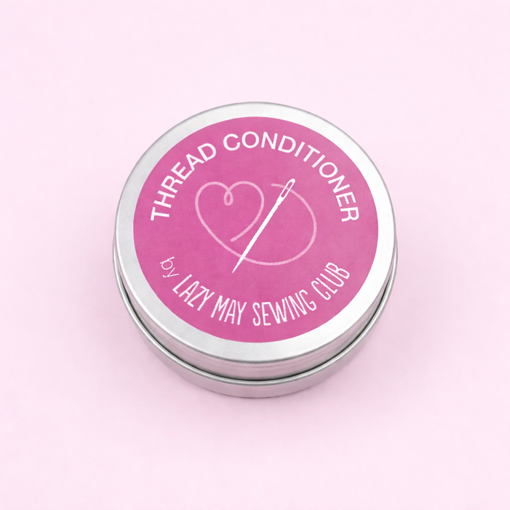 Thread conditioner container with pink label on a light pink background