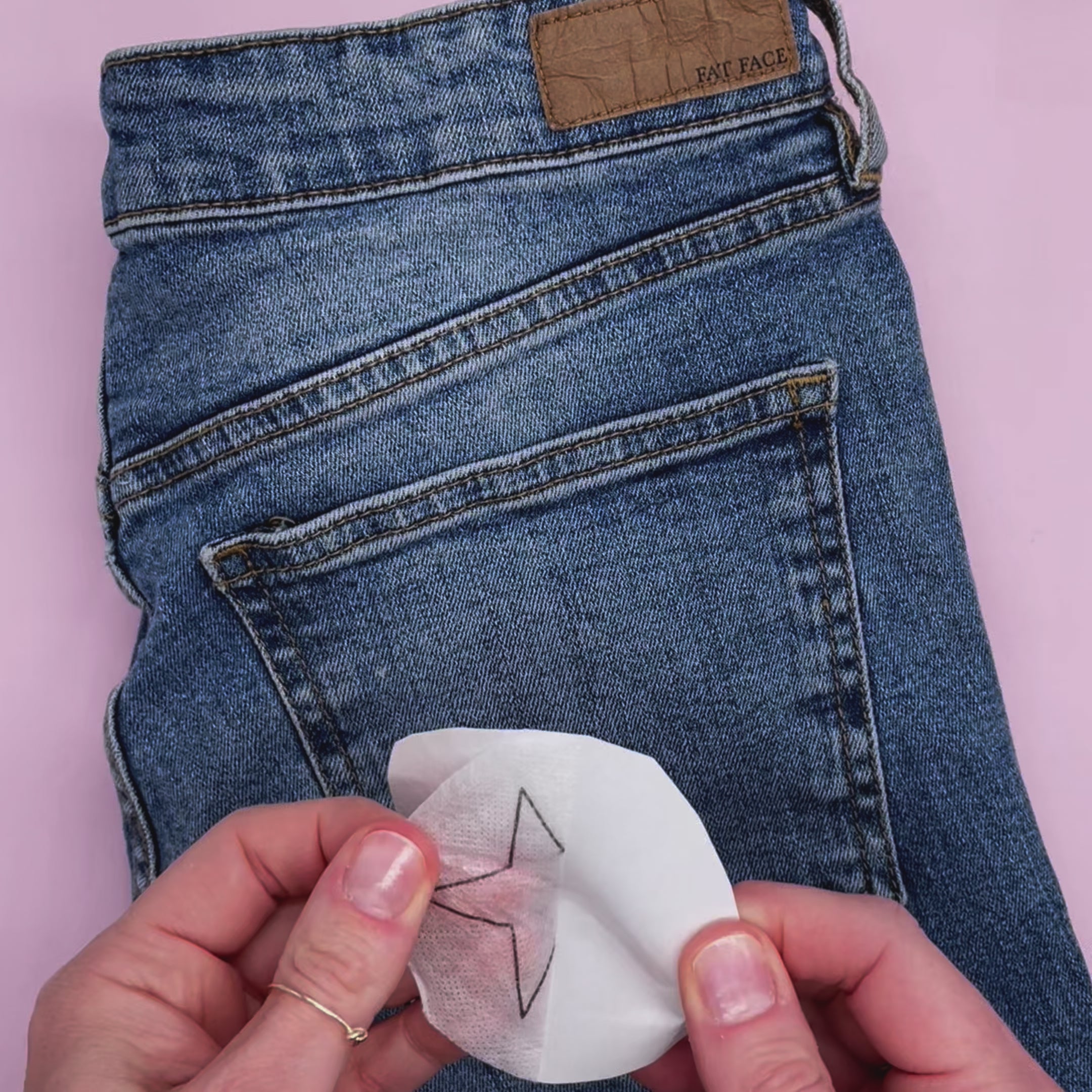 Applying a water-soluble stick and stitch embroidery pattern to denim, demonstrating how these dissolving embroidery patterns can be used for upcycling and modern embroidery designs.