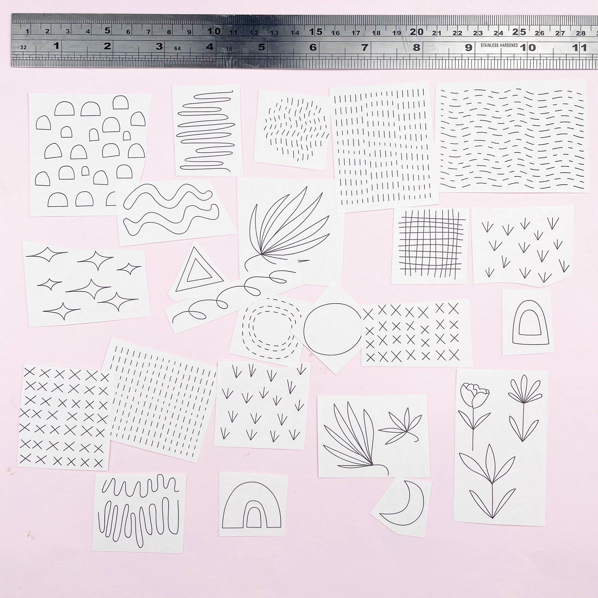 Iron-On Embroidery Patterns: Slow Stitching Textures with various minimalist black line designs on white paper squares on pink background