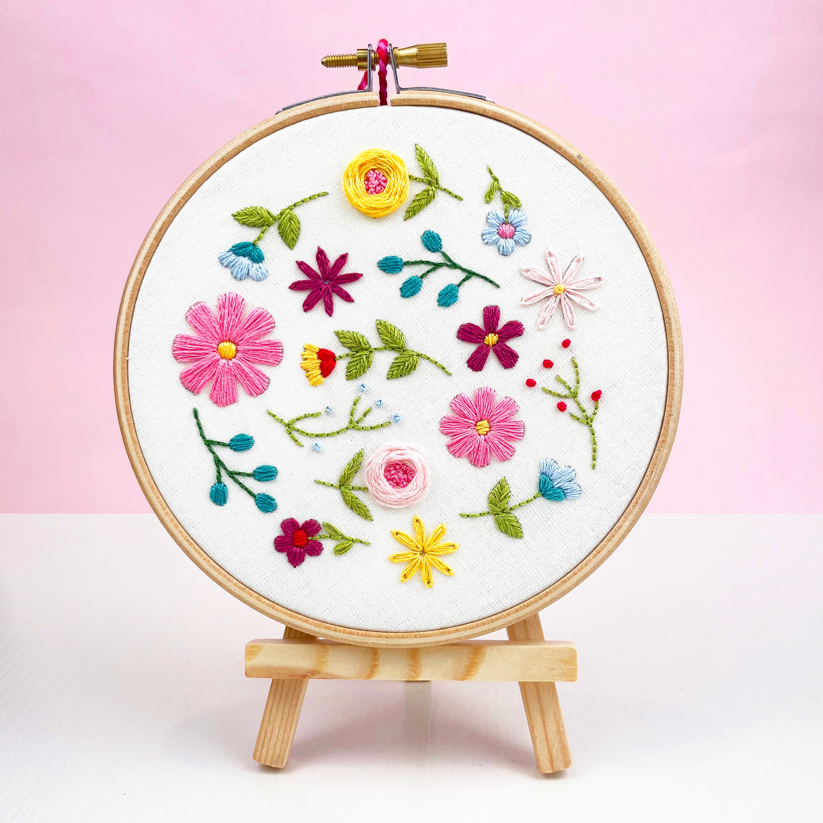 Wildflower embroidery hoop displayed against pink background – easy stitching kit for adults or gift for crafter.