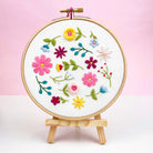 Wildflower embroidery hoop displayed against pink background – easy stitching kit for adults or gift for crafter.