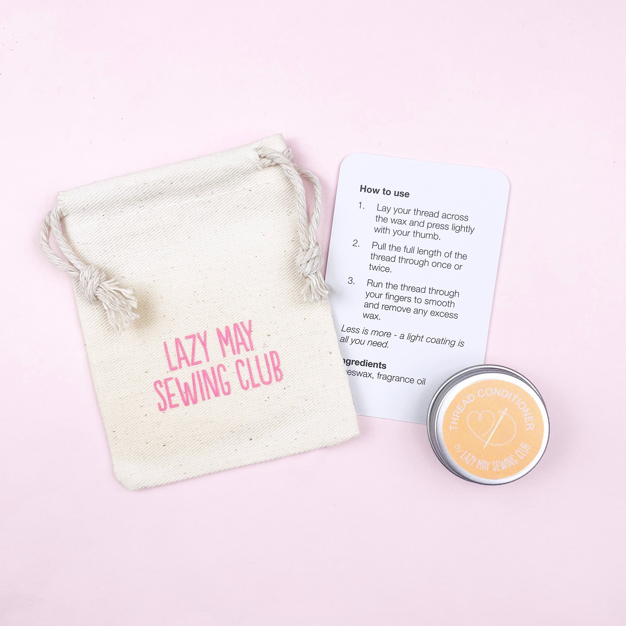 Lazy May Sewing Club product with a drawstring bag, instructions, and a small container on a pink background