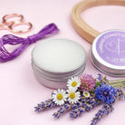 Thread conditioner container with flowers and scissors on a pink background