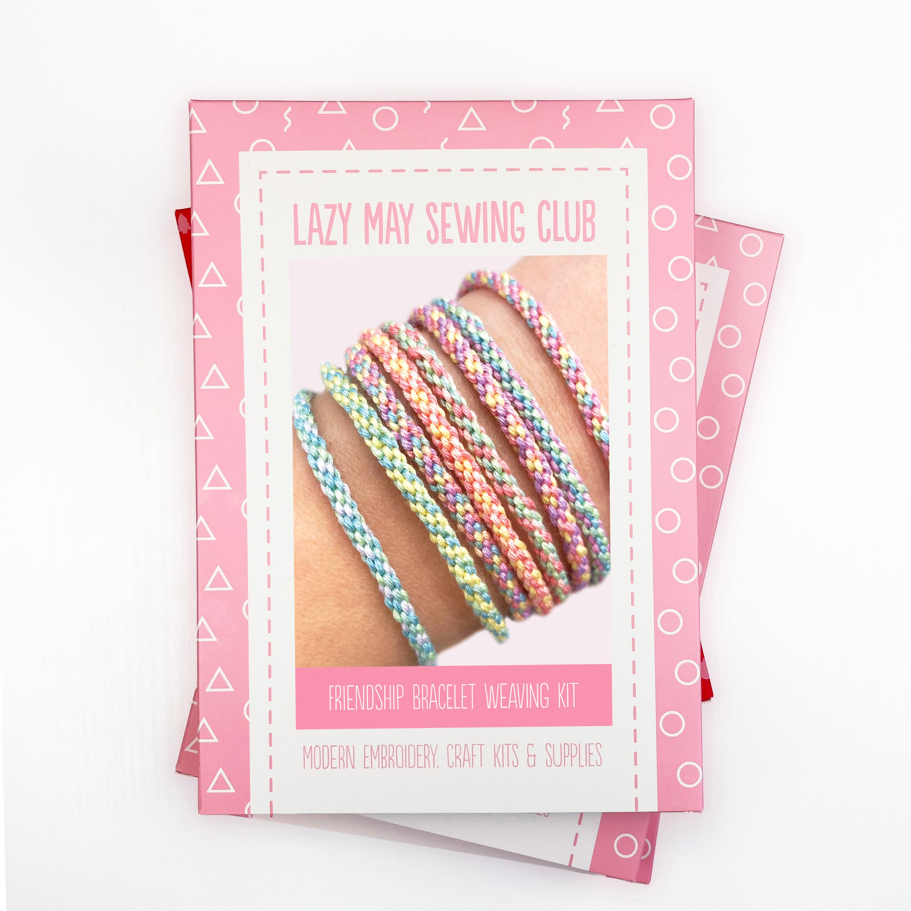 Flat lay of the Friendship Bracelet Kit packaging with pastel sample bracelet photo and Lazy May Sewing Club branding.