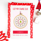 Embroidery kit packaging with a Christmas-themed design and 'Lazy May Sewing Club' branding.
