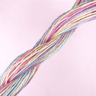 Pastel-colored embroidery threads twisted together against a soft pink background for easy embroidery projects