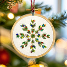 Embroidered snowflake ornament on a Christmas tree with blurred lights in the background