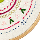 Embroidery hoop with colorful floral and geometric patterns on a white background