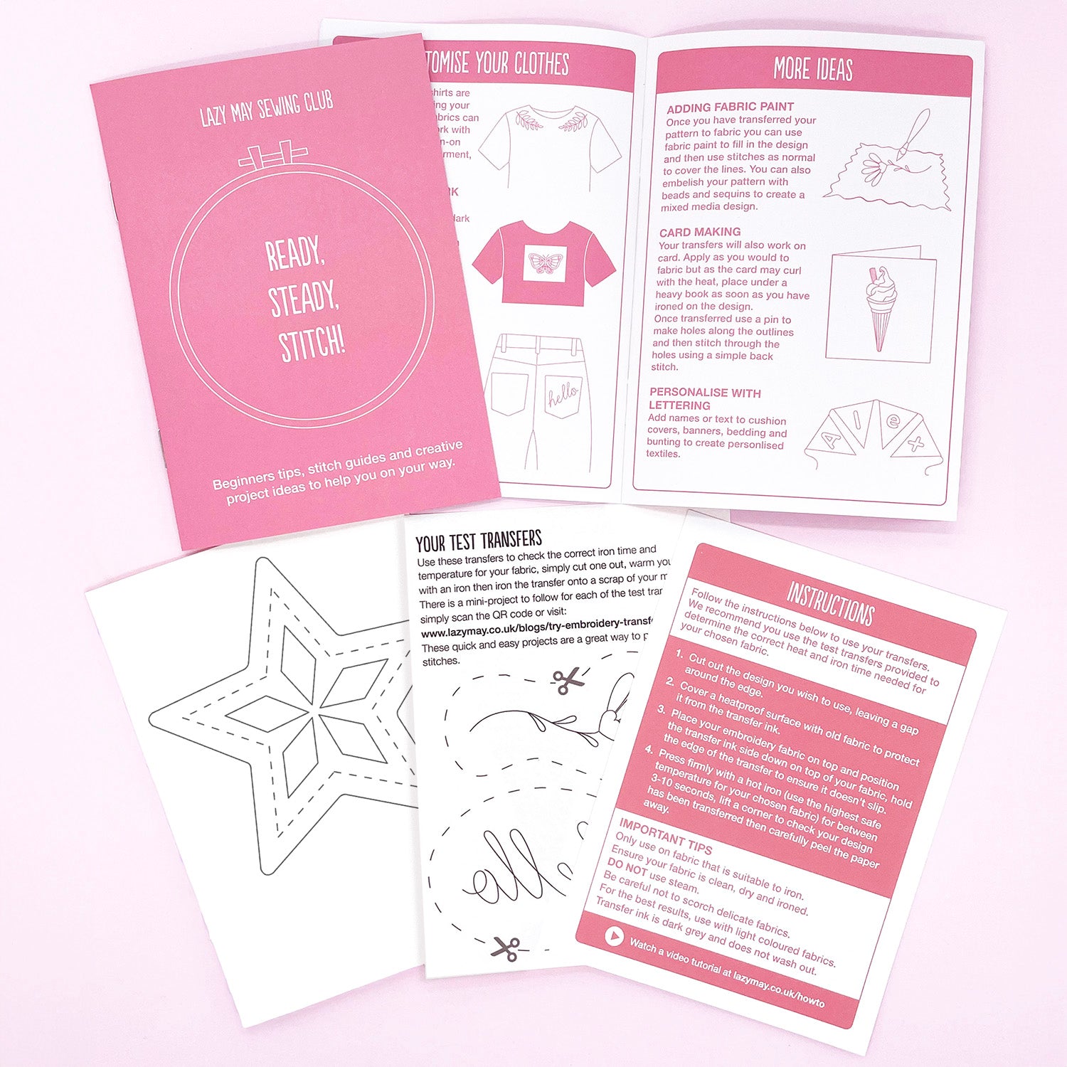 A flat lay of sewing club instruction sheets and templates on a pale pink background. The set includes a pink cover card reading 'Lazy May Sewing Club' and 'Ready, Steady, Stitch!', an open booklet with sewing ideas, and several white pattern transfer sheets with pink headers.