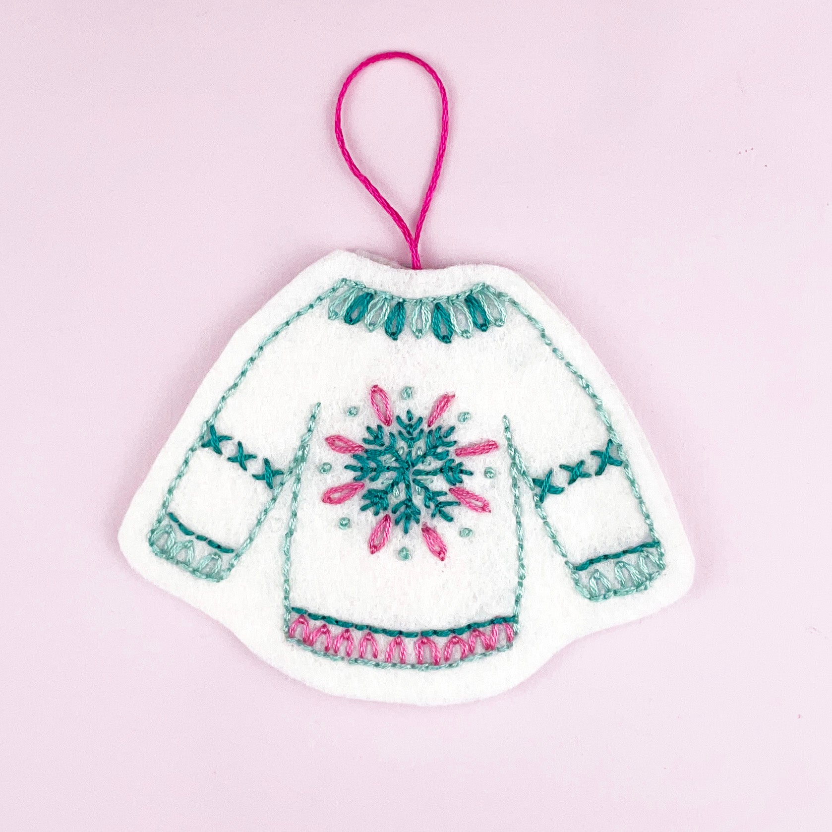 Decorative patch of a knitted sweater with a snowflake design on a pink background