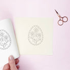 iron on embroidery Floral egg designs on paper with scissors on a pink background