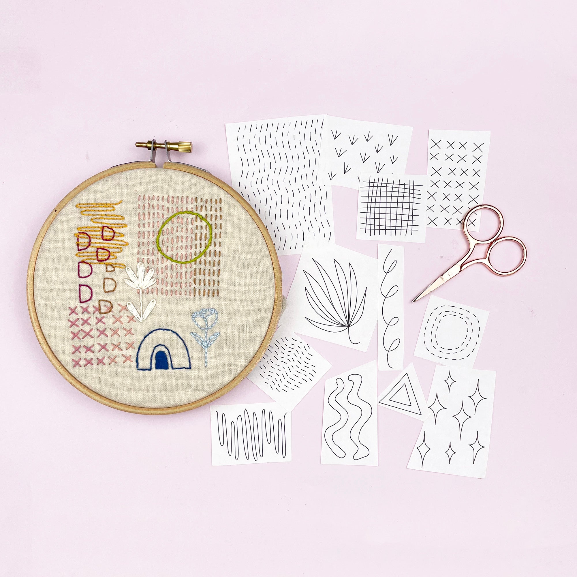 Iron-On Embroidery Patterns: Slow Stitching Textures showing hoop with stitched designs and pattern templates with scissors on pink background