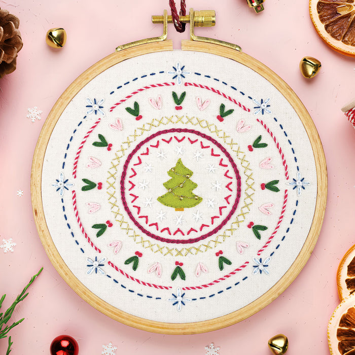 Christmas Stitch Sampler Embroidery Kit with a green tree surrounded by colourful festive embroidery stitches.