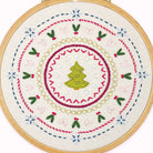 Embroidery hoop with a Christmas-themed design featuring a tree and festive patterns.