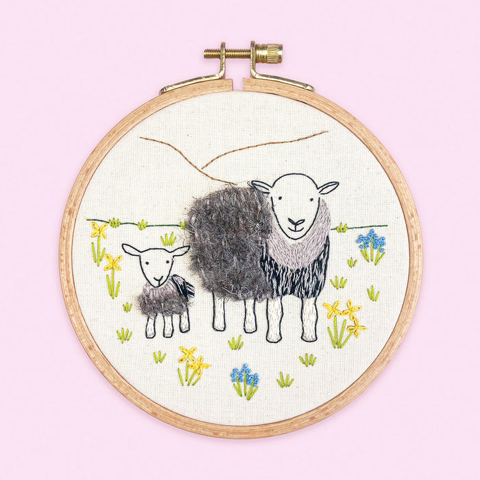 Lake District Herdwick Sheep Embroidery Kit showing a stitched ewe and lamb surrounded by simple wildflowers.