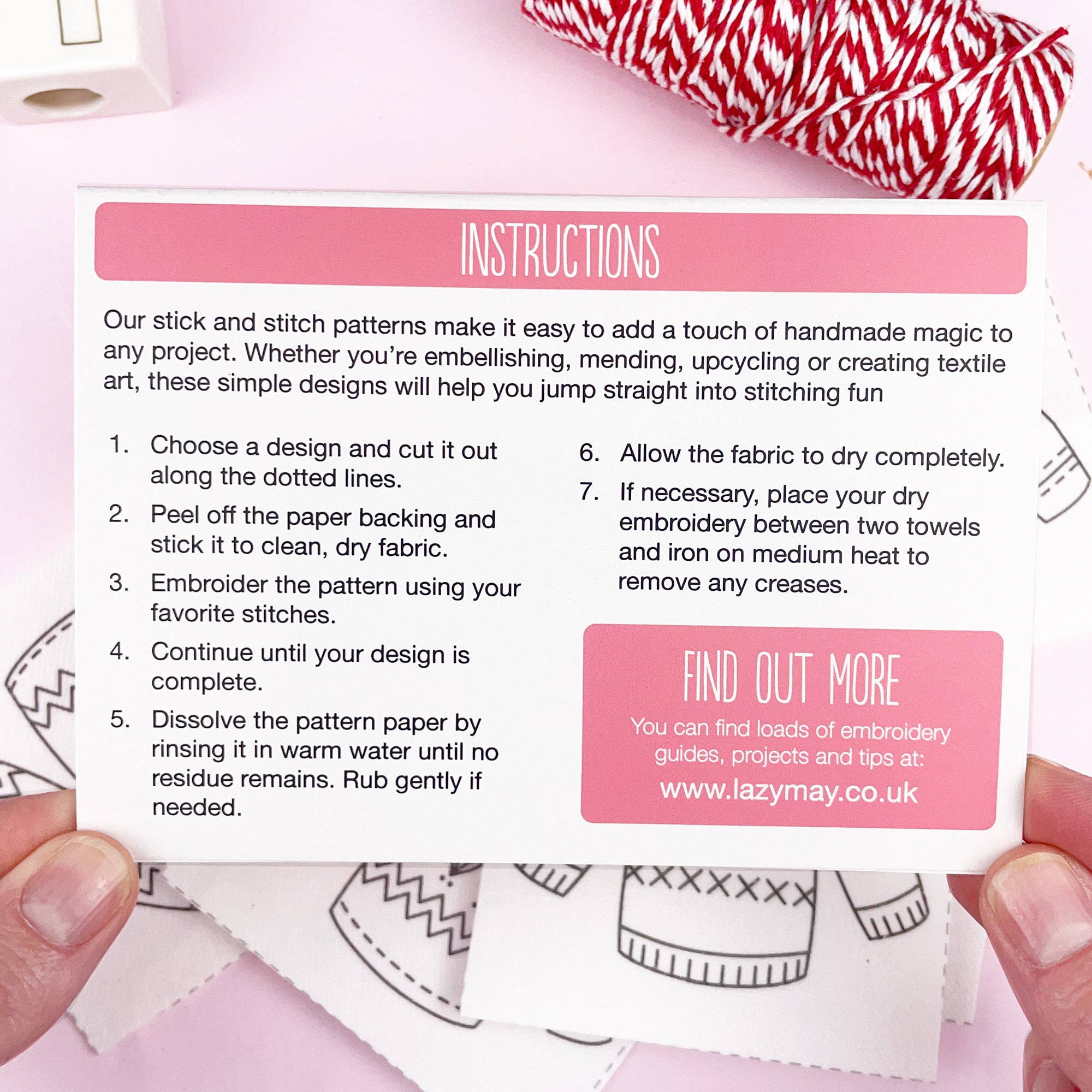 Instructions card for stick and stitch patterns held by hands with a red and white fabric in the background.