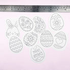 Decorative Easter egg and bunny templates with a ruler for scale on a light pink background.