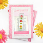 Embroidery kit packaging for 'Lazy May Sewing Club' with flowers on a white background. Box for a sew your own bookmark kit