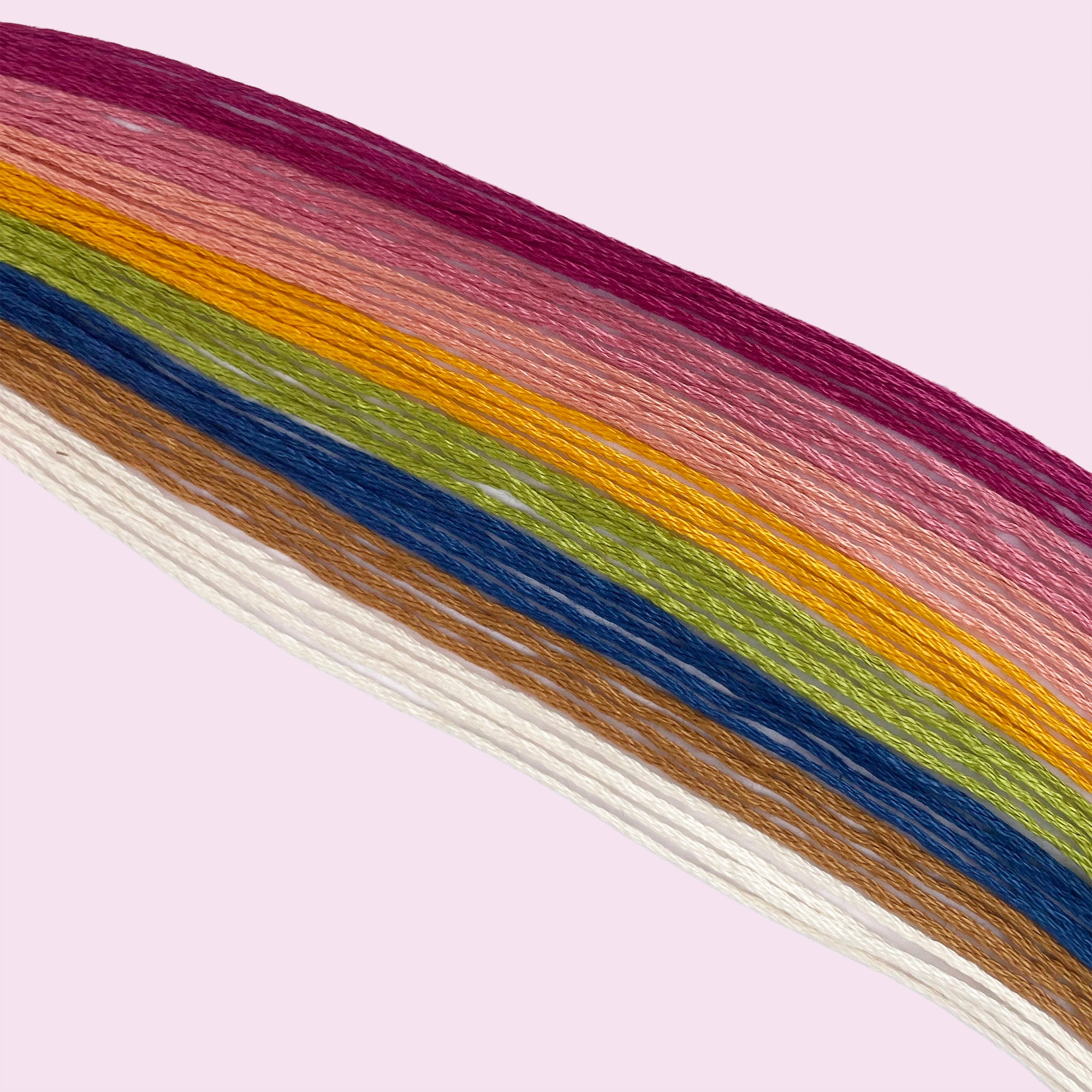 Colorful natural thread palette arranged on a light background for beginner embroidery projects.