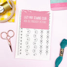 Lazy May Sewing Club iron-on embroidery patterns with sewing tools on a white background