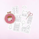 Iron-On Embroidery Patterns: 16 Little House Themed Designs showing house sketches, scissors, and embroidered house on red gingham fabric.