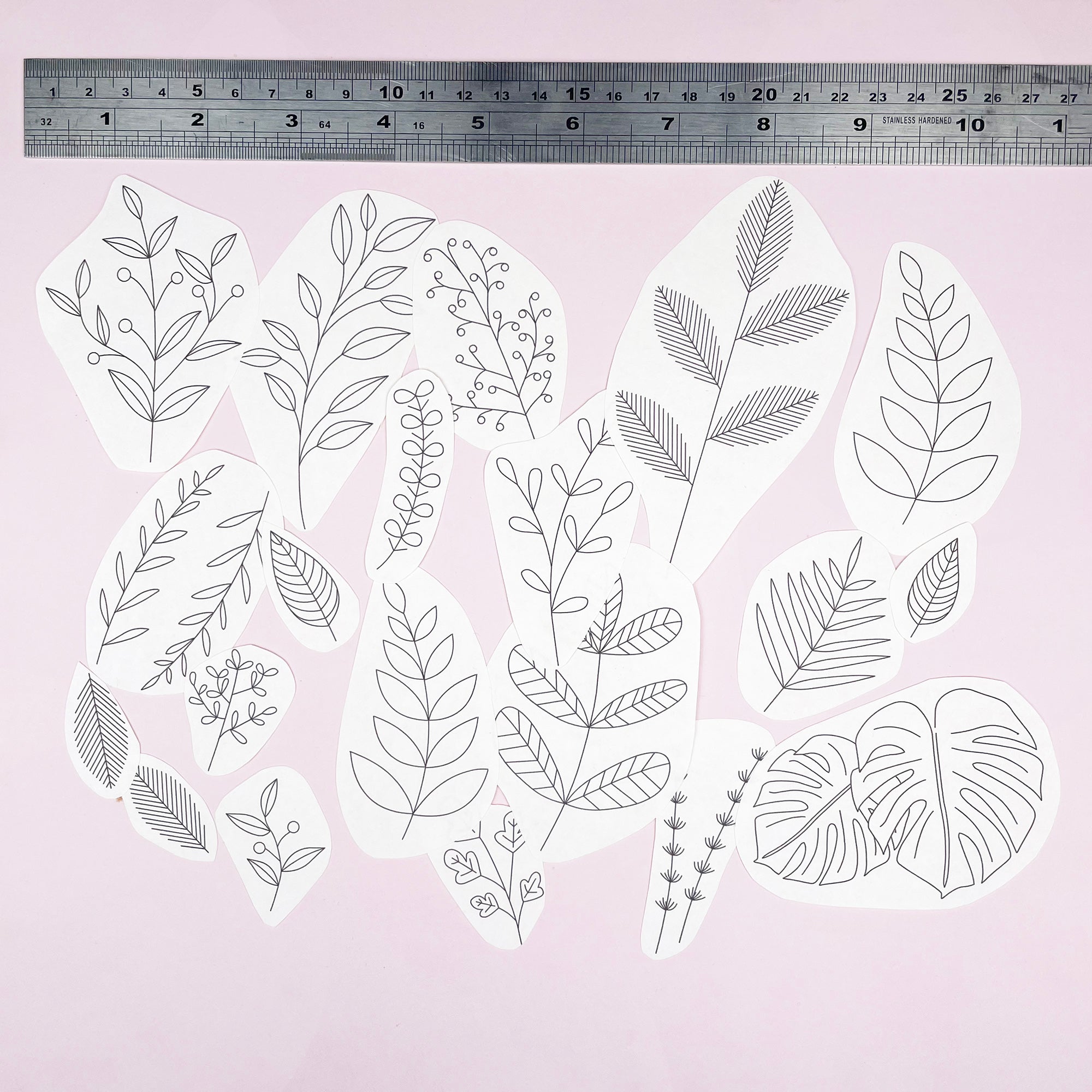 Set of various leaf and branch embroidery designs on a light pink background with a ruler at the top.