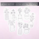 Set of floral and vase embroidery patterns with a ruler for scale on a light pink background