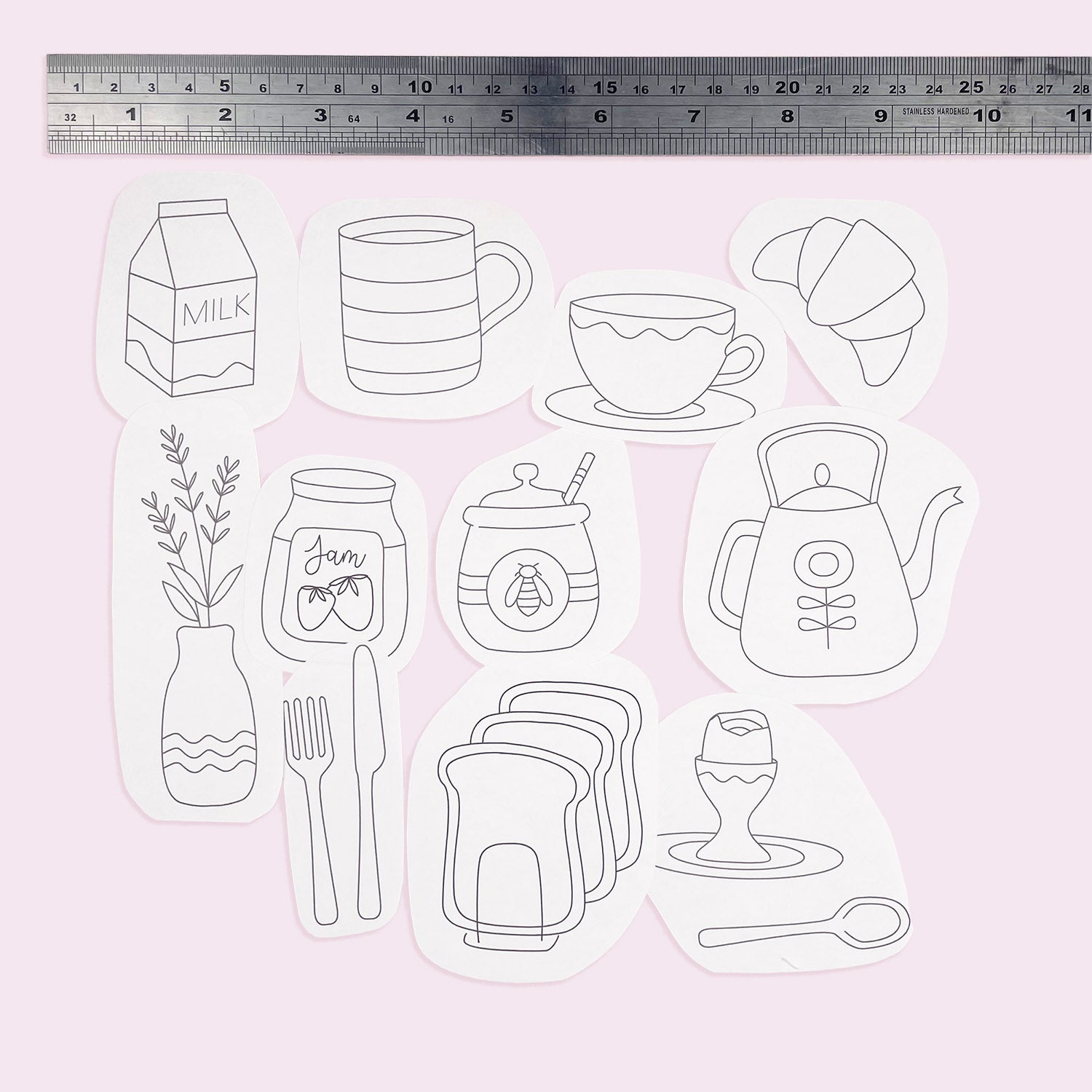 Set of iron on embroidery transfer patterns of kitchen items on a light pink background with a ruler at the top.
