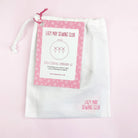 White drawstring bag with a pink tag from Lazy May Sewing Club containing embroidery starter kit materials