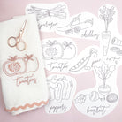 Set of vegetable-themed coloring sheets with a white towel and scissors on a pink background